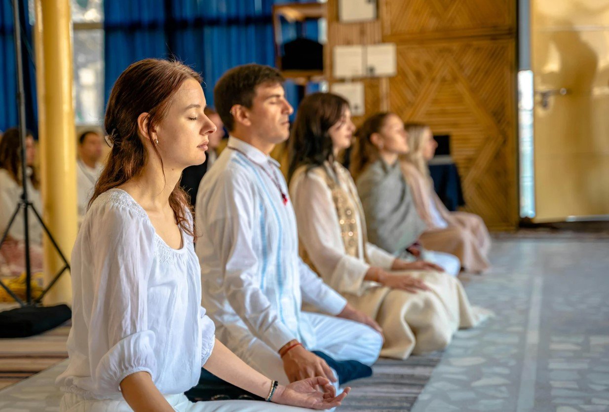 A student seated cross-legged in a quiet meditation posture