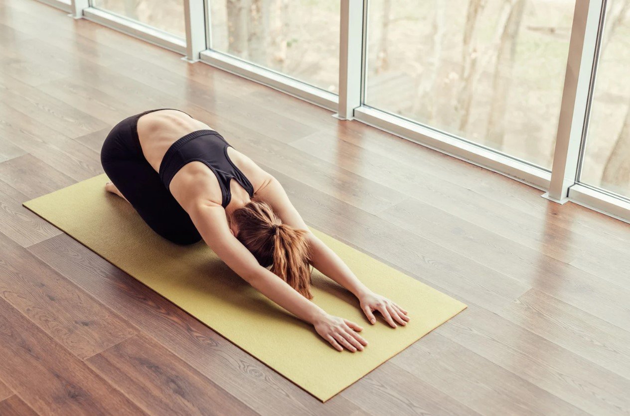 A student resting in a supported relaxation pose with props