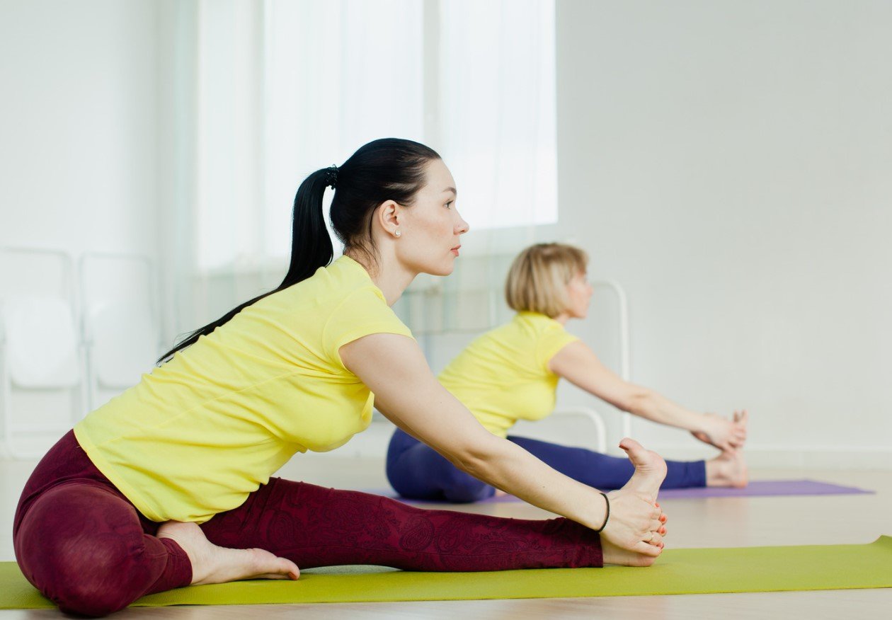 A student folding gently forward in a seated forward bend